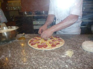 Kucharz przyrządza pizze